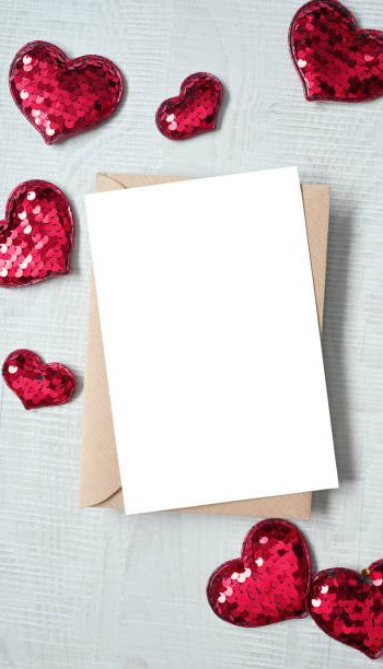 Blank white greeting card with brown envelop and hearts on marble table. Mockup valentines day concept